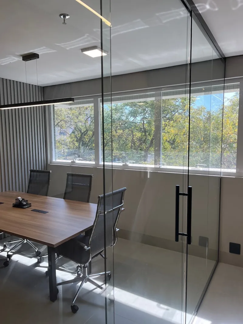 Sala de reuniões do escritório com mesa e janelas amplas