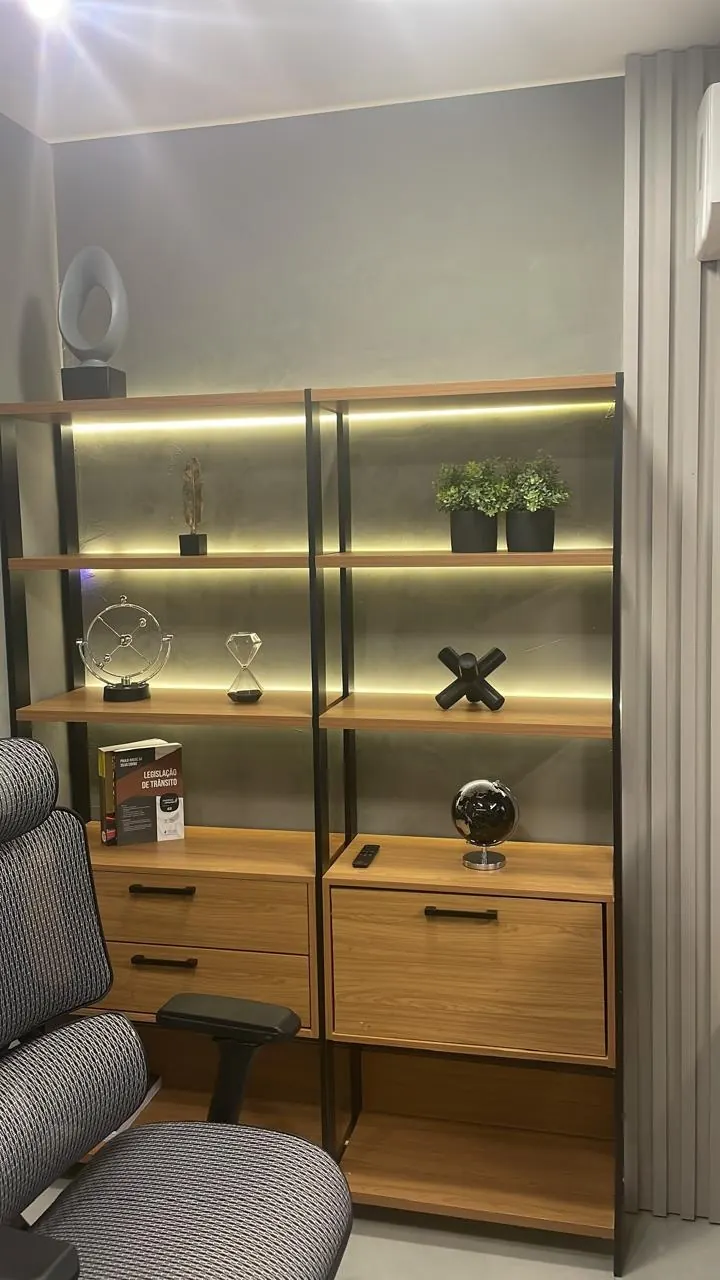 Estante do escritório com livros de Direito de Trânsito e objetos decorativos
